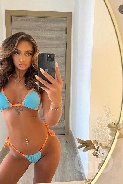 Indie, high class English escort London, mirror selfie in a turquoise and orange bikini
