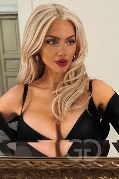 Devon, glamour model and London escort, in a black top with red lipstick