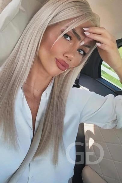 Devon selfie in a white shirt, long platinum blonde hair
