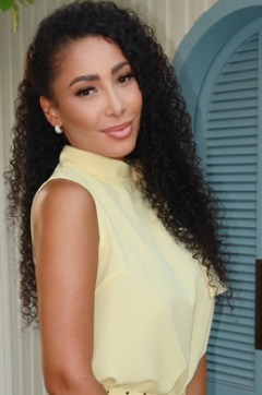 Nicole thumbnail - long dark curls and a pale yellow sleeveless top